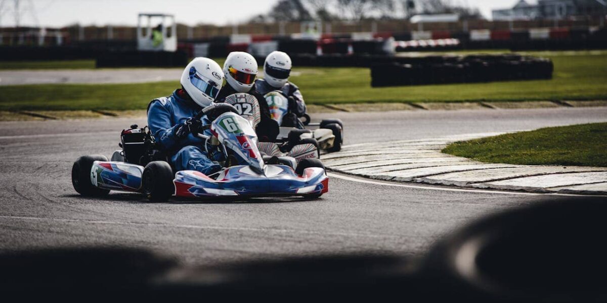 Two go-karts racing on a track in Twente, outdoor and indoor settings visible