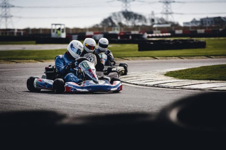 Two go-karts racing on a track in Twente, outdoor and indoor settings visible