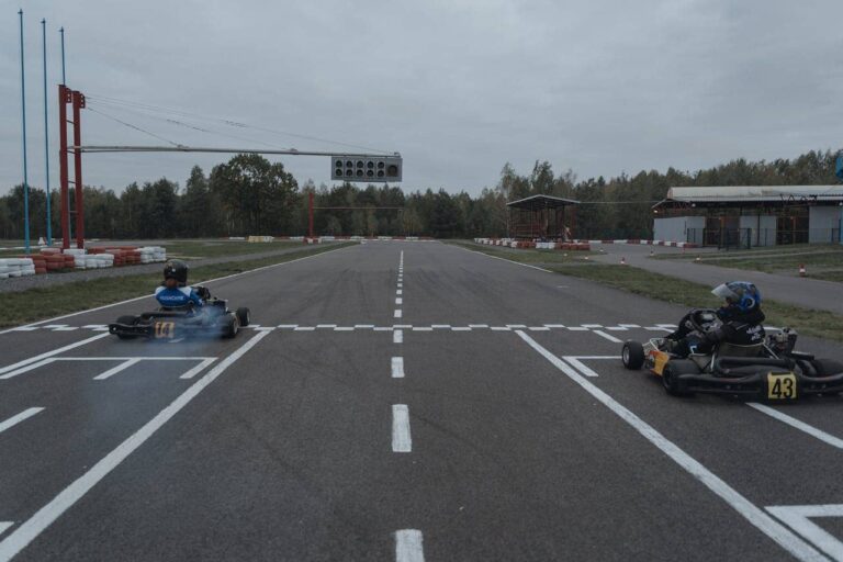 Person racing a go-kart indoors, cornering at speed with focus and determination