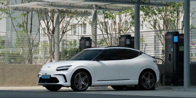 Man charging an electric car at a charging station in the Netherlands