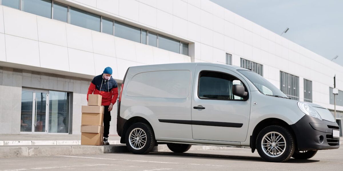 A white company van parked outside an office building