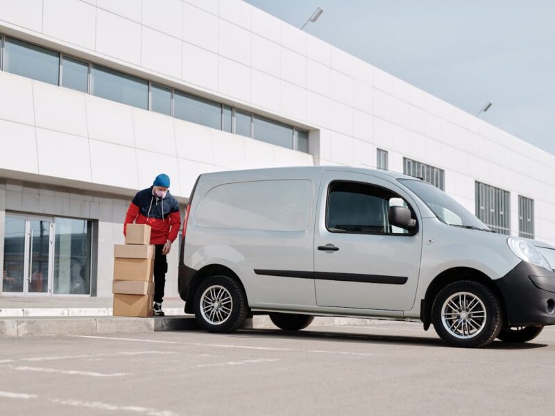 A white company van parked outside an office building