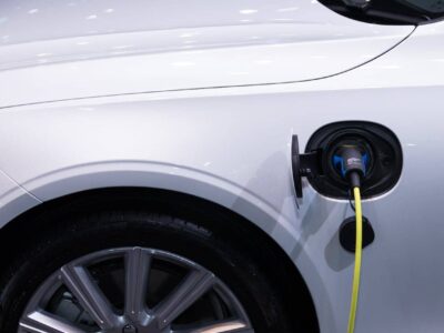 Technician in workshop repairing electric vehicle during battery maintenance