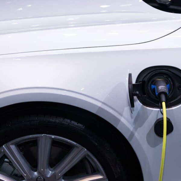 Technician in workshop repairing electric vehicle during battery maintenance