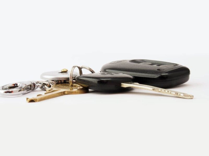 A misplaced car key lying on a hallway table near a door hook, illustrating stress-free solutions for lost car keys