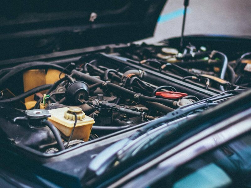Car parts on a workbench with a mechanic in the background