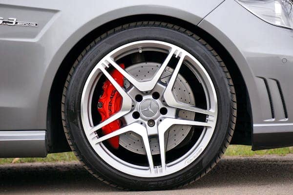 Close-up of a car brake disc with wheel removed, on a blue background