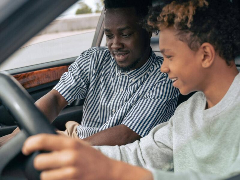 Young driver behind the wheel, focusing and checking side mirror