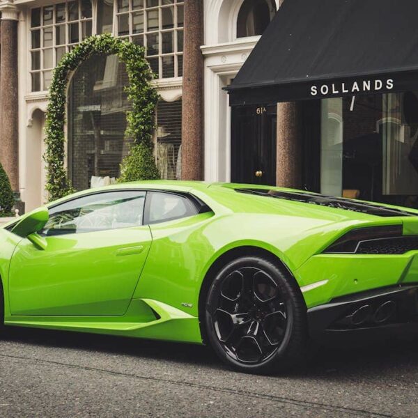 Orange Lamborghini parked in front of Dubai skyline