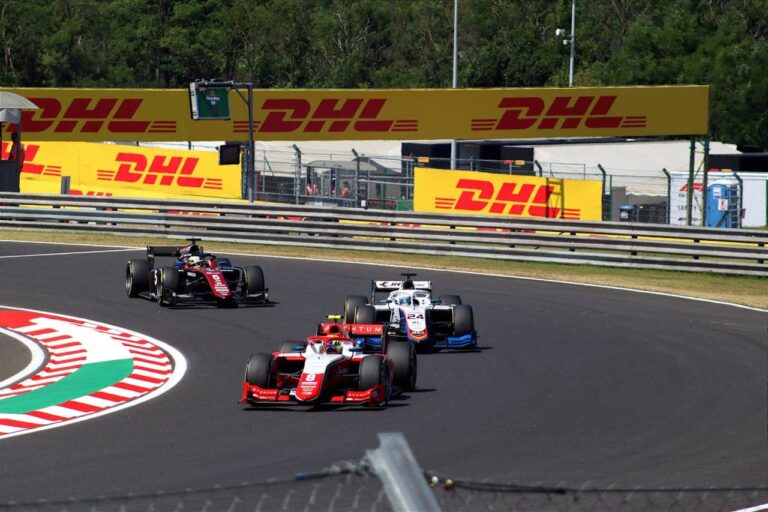 Formula 2 cars on a racetrack during a race.