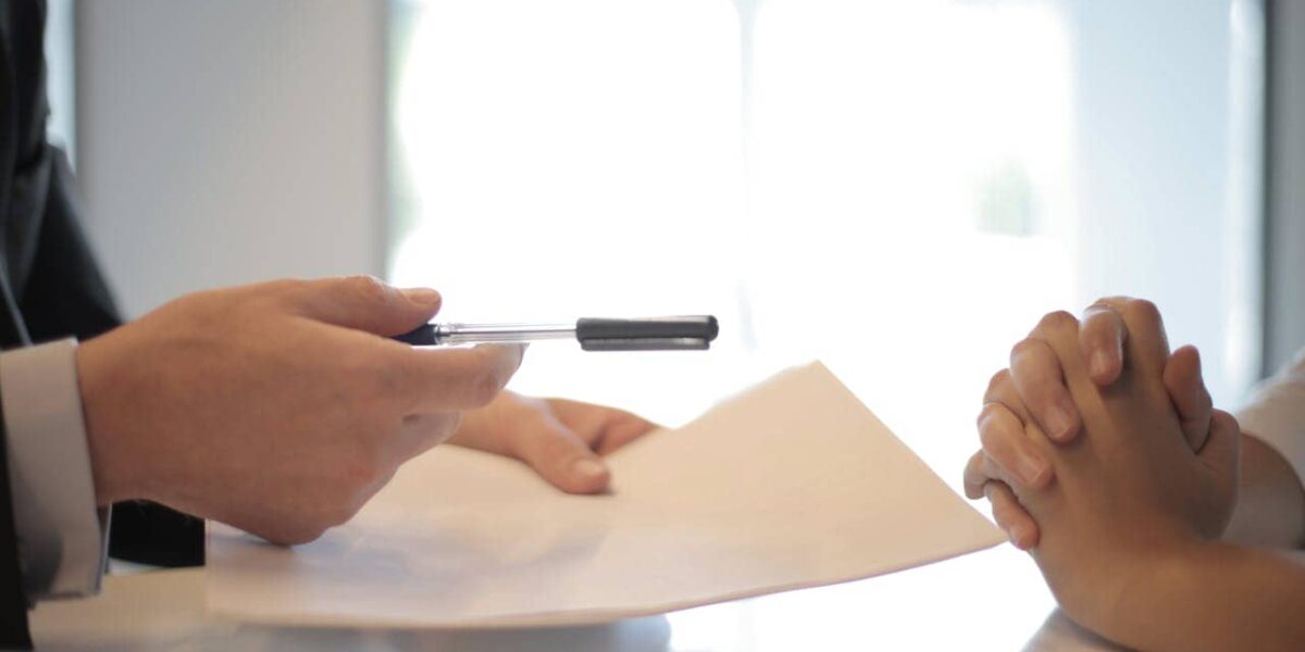 Person at a desk comparing car insurance policies for a business vehicle
