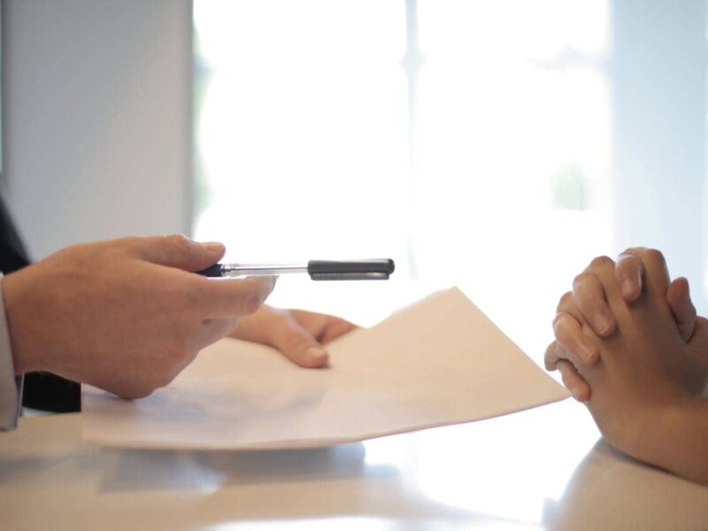 Person at a desk comparing car insurance policies for a business vehicle
